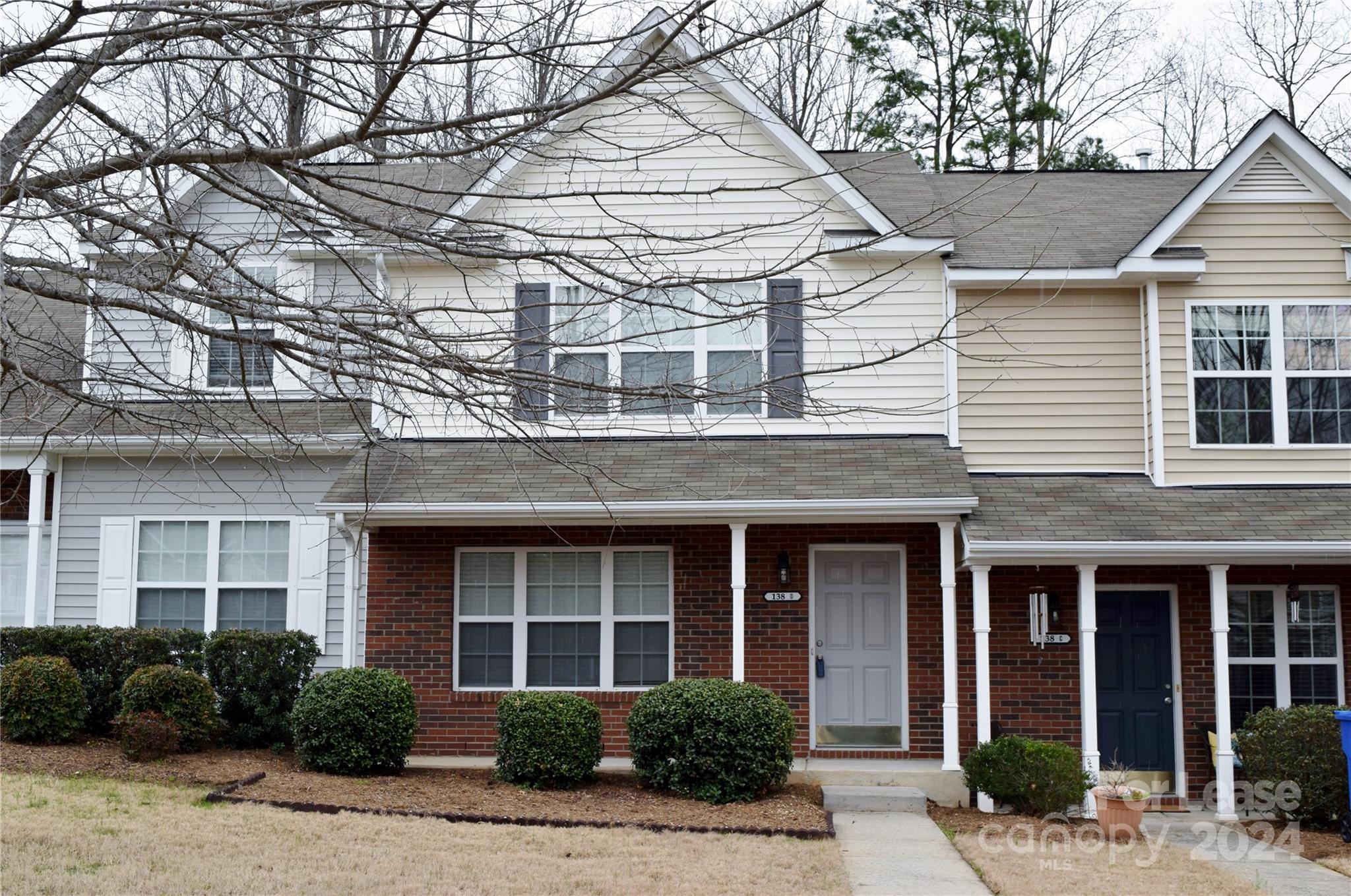 front view of a brick house with a small yard