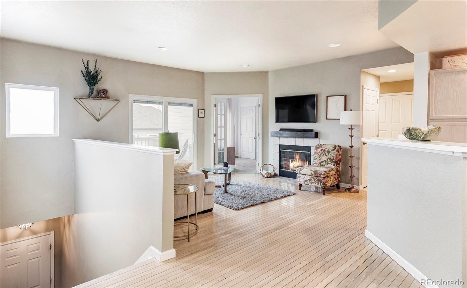 a living room with furniture a flat screen tv and a fireplace