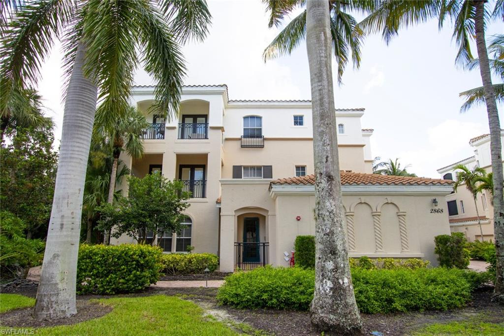 a front view of a house with a garden and palm trees