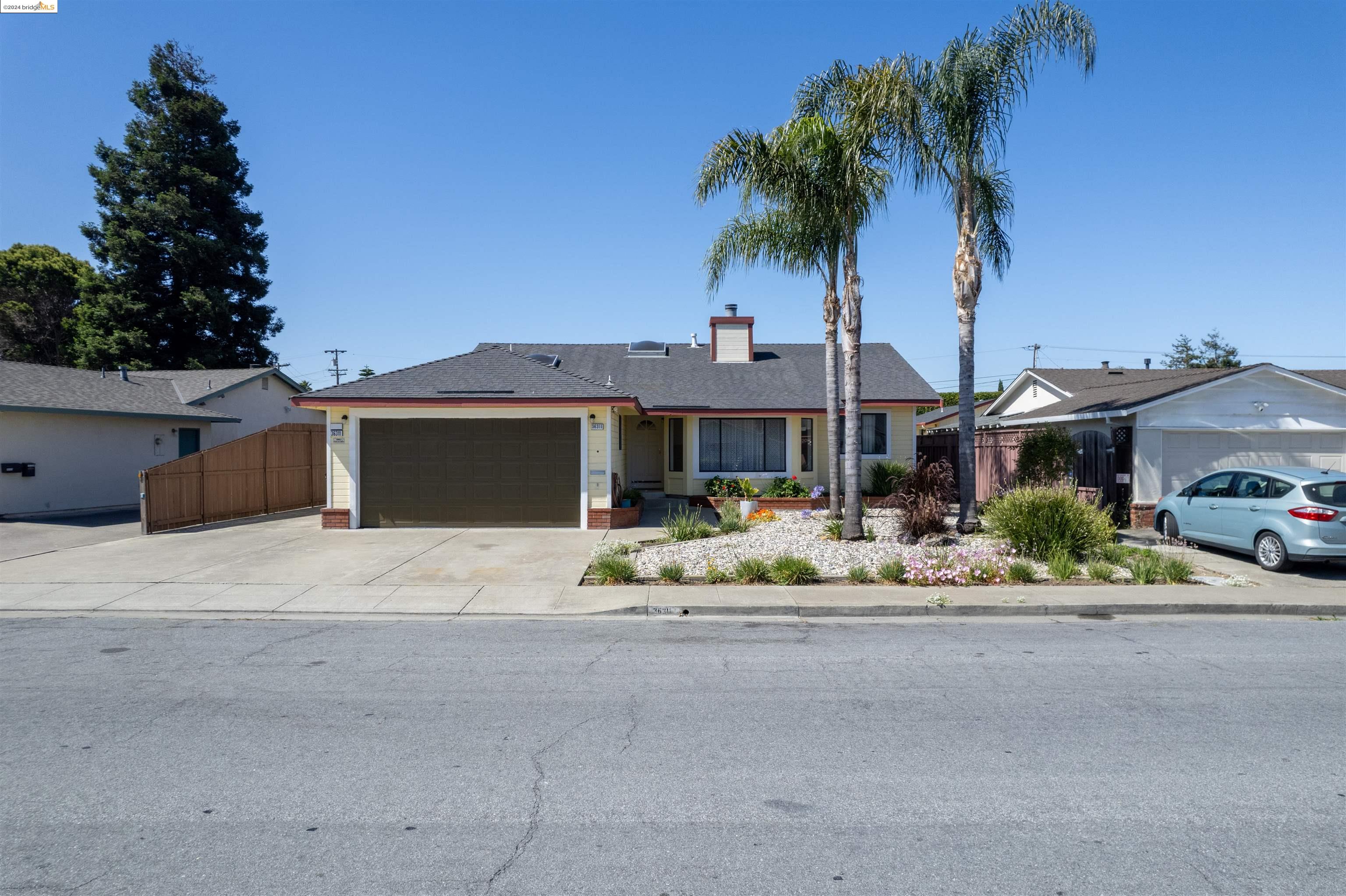 a front view of house with yard and trees in the background