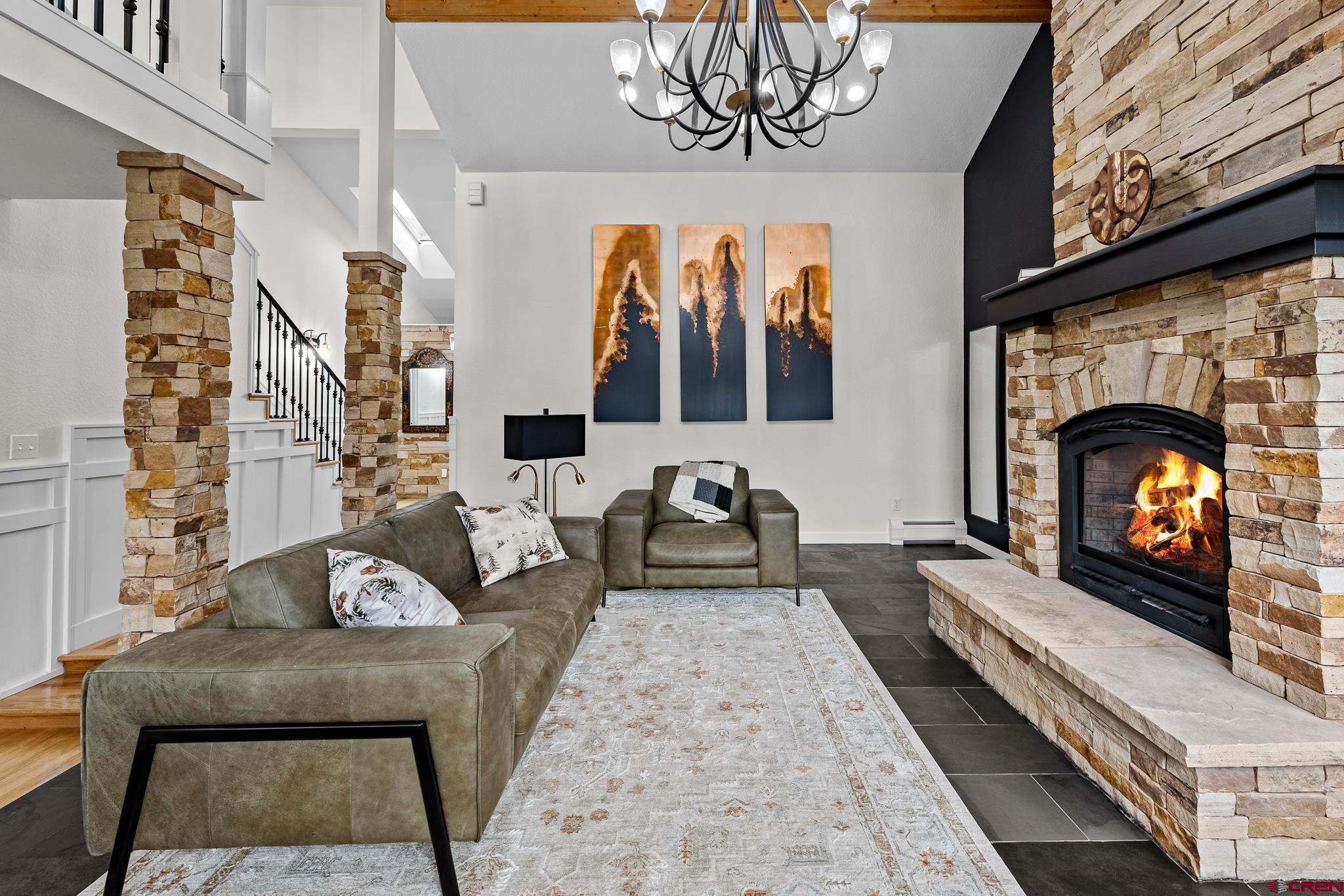 a living room with furniture a fireplace and a large window