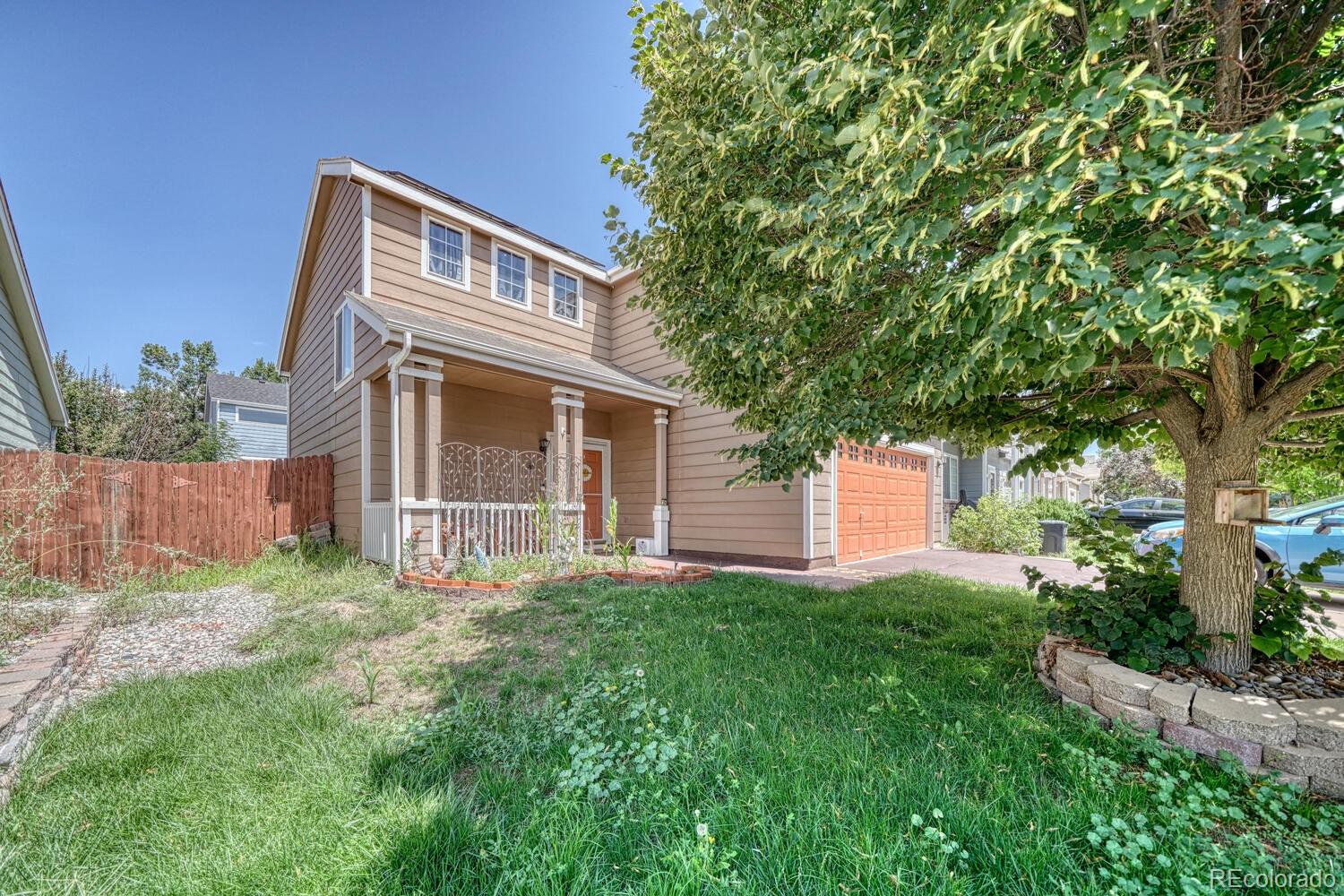 a front view of house with yard and trees in the background