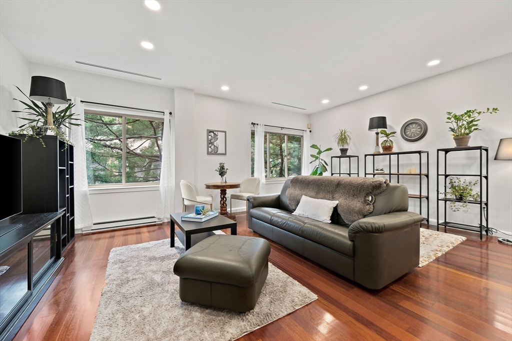 a living room with furniture tv and wooden floor