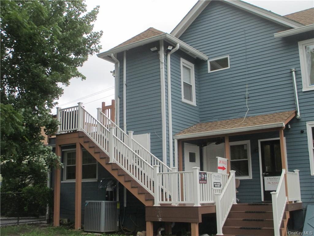 a front view of house along with deck and outdoor seating