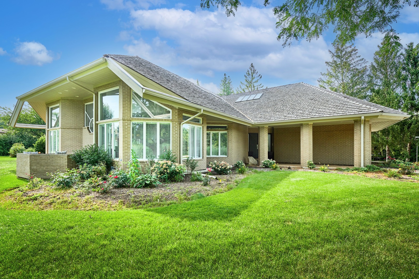 a front view of a house with a garden and plants