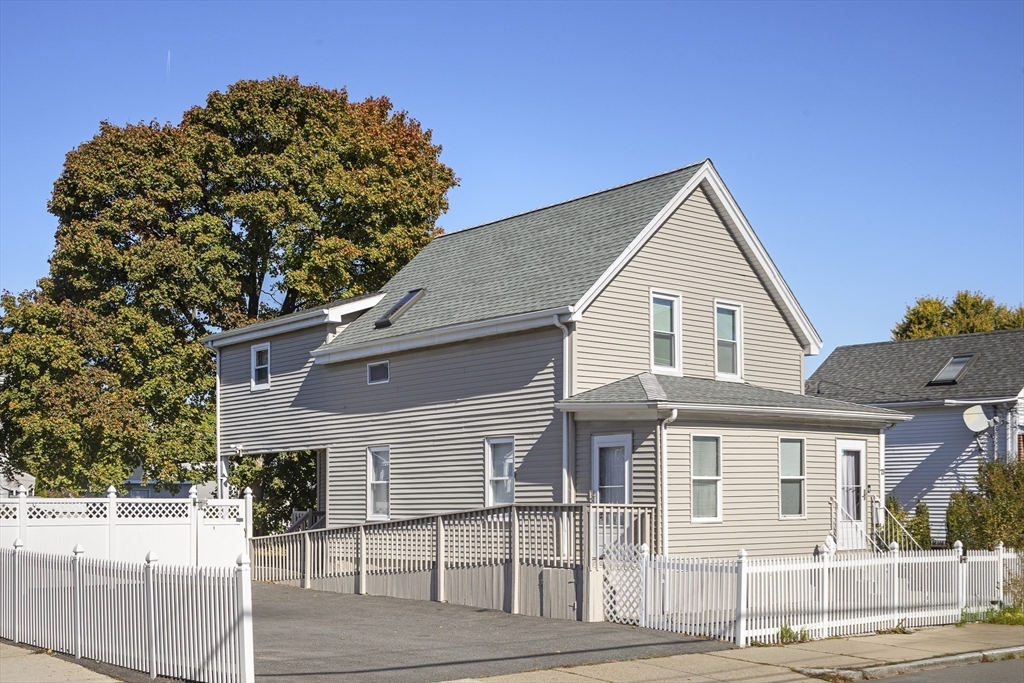 a view of a white house next to a yard