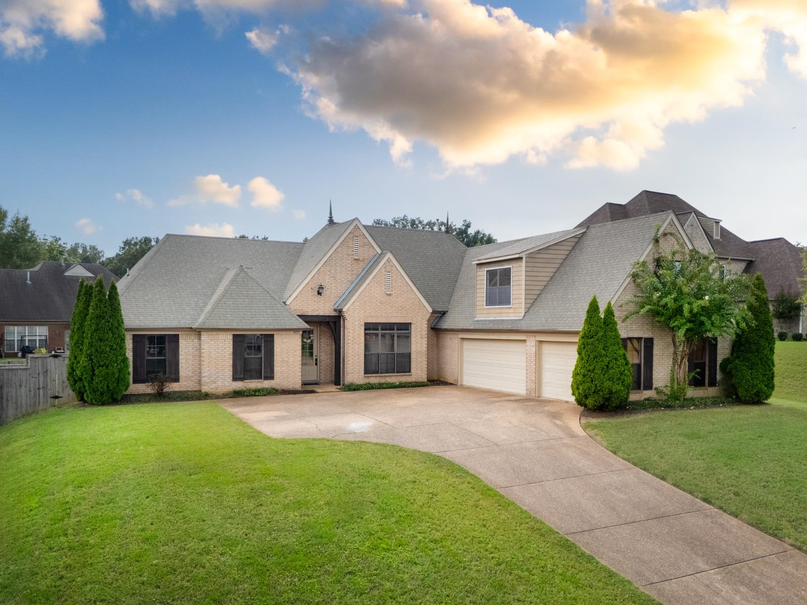 View of front of property with a garage and a yard