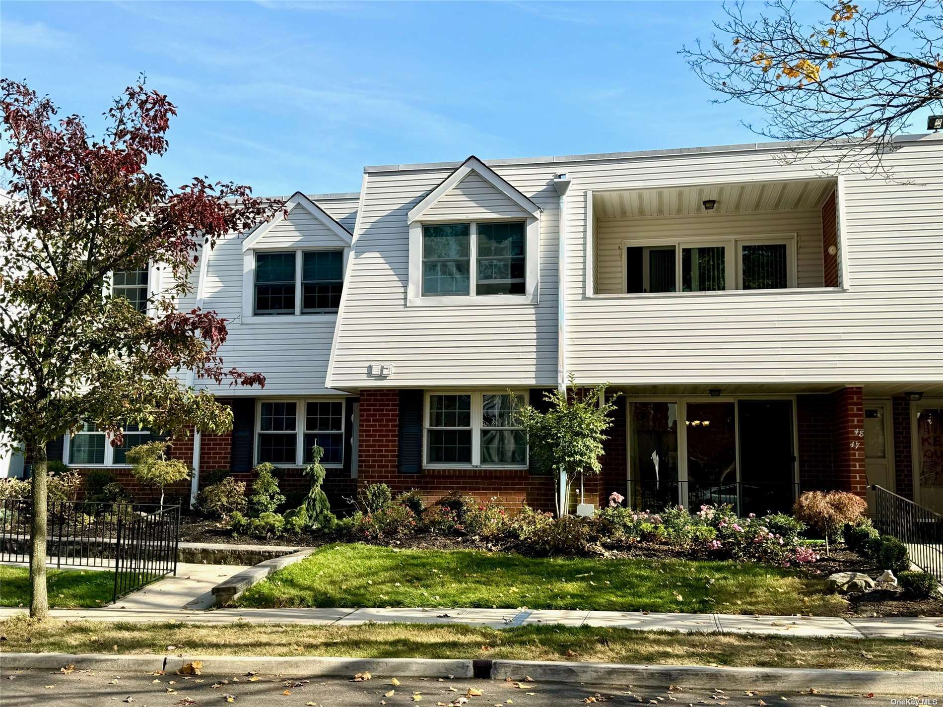 a front view of a house with lots of windows and plants