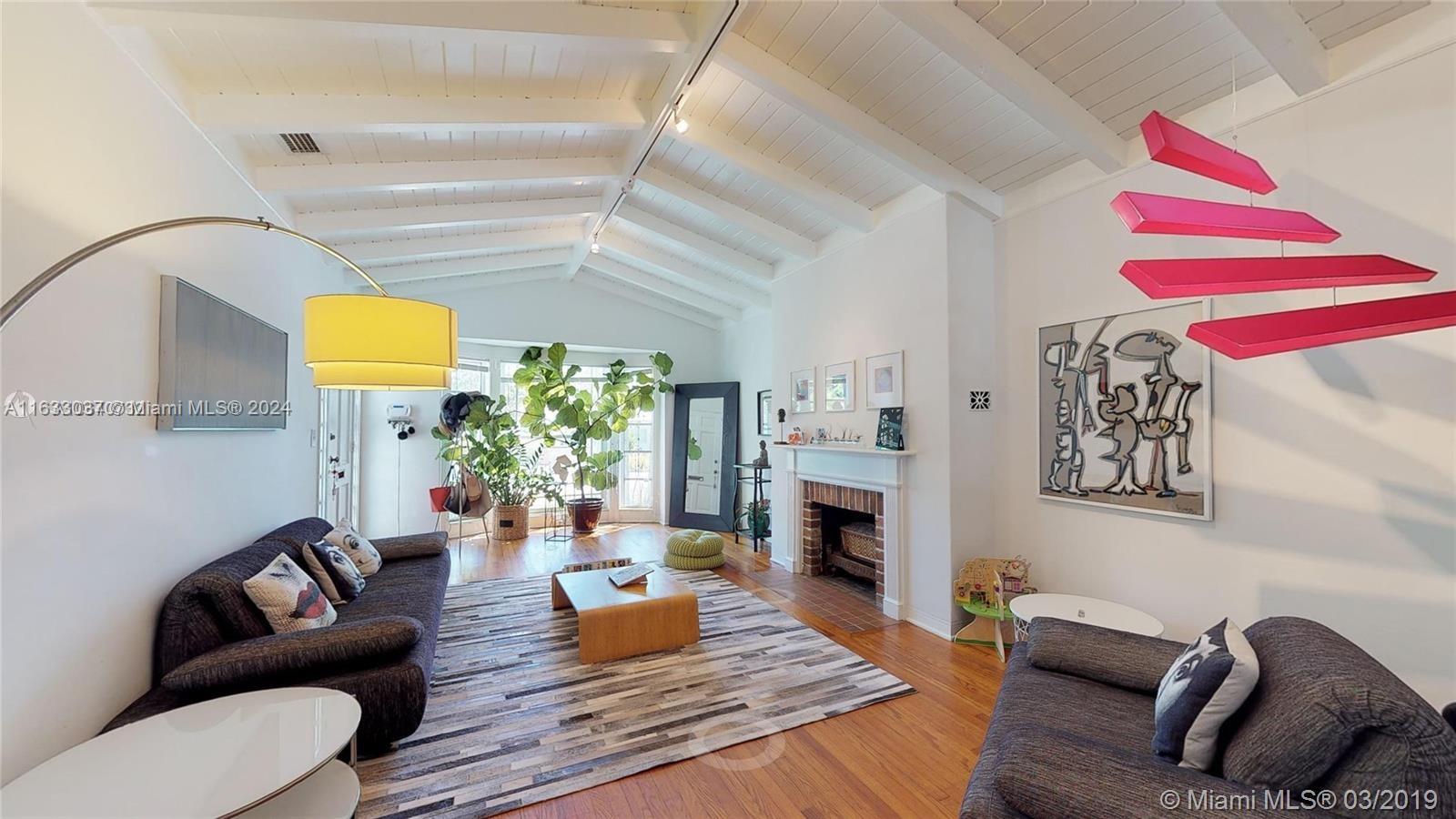 a living room with furniture fireplace and a window