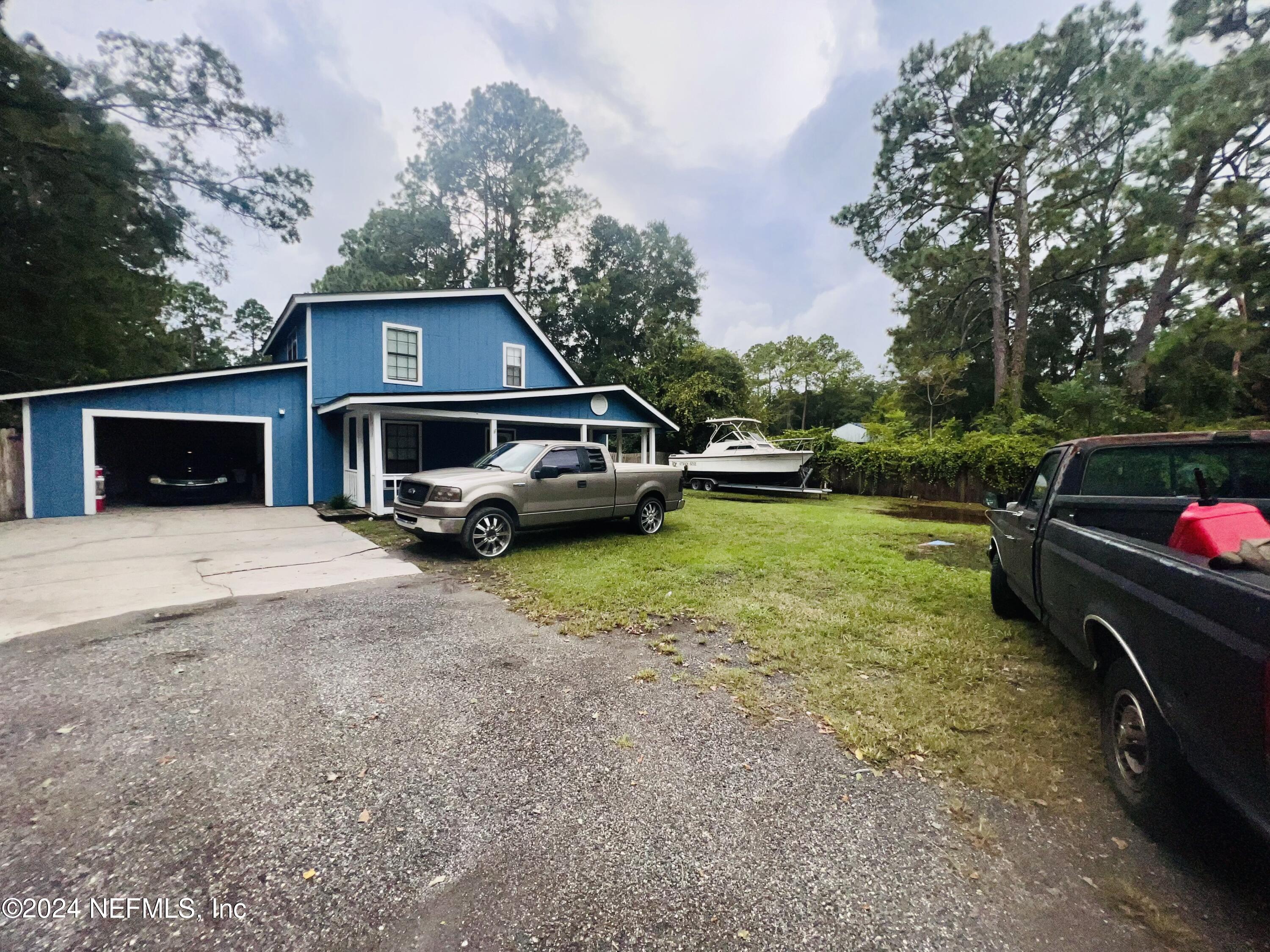 a car parked in front of a house with a yard