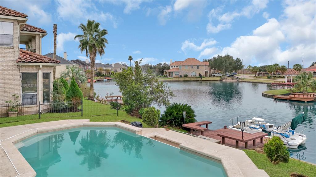 a swimming pool with outdoor seating and lake view