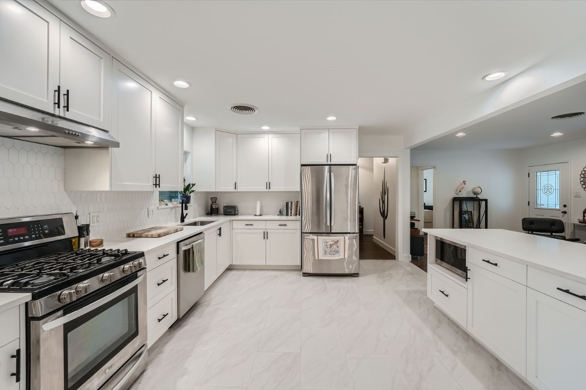 a kitchen with white cabinets and white appliances