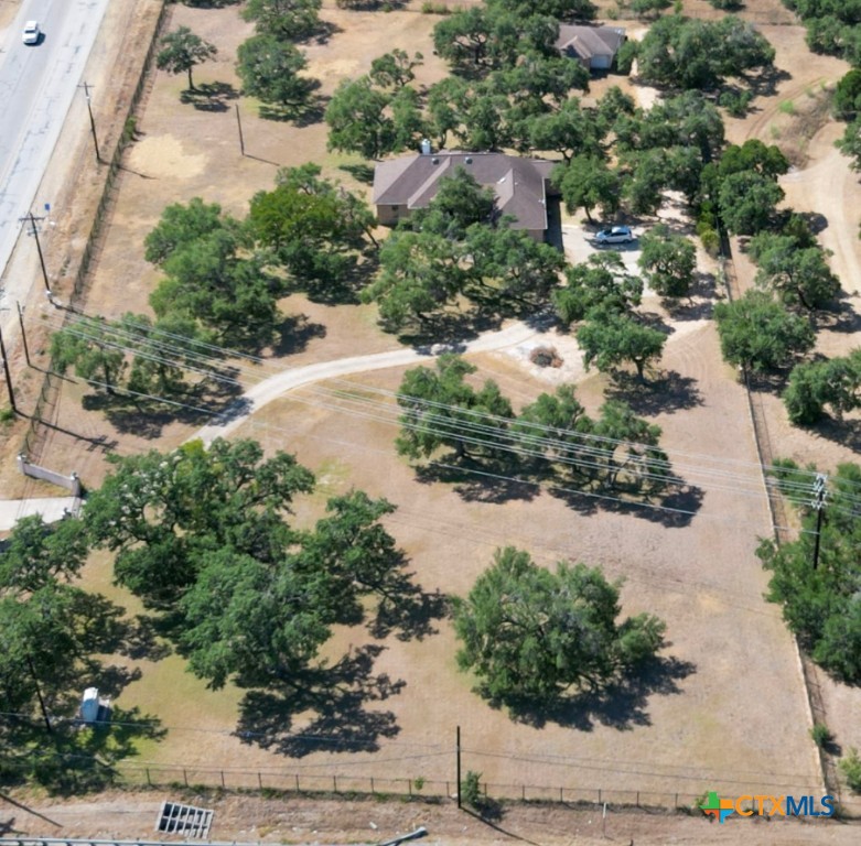 an aerial view of a house with a yard and mountain view in back