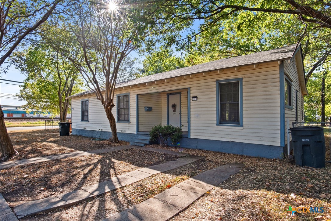 a front view of a house with a yard and potted plants