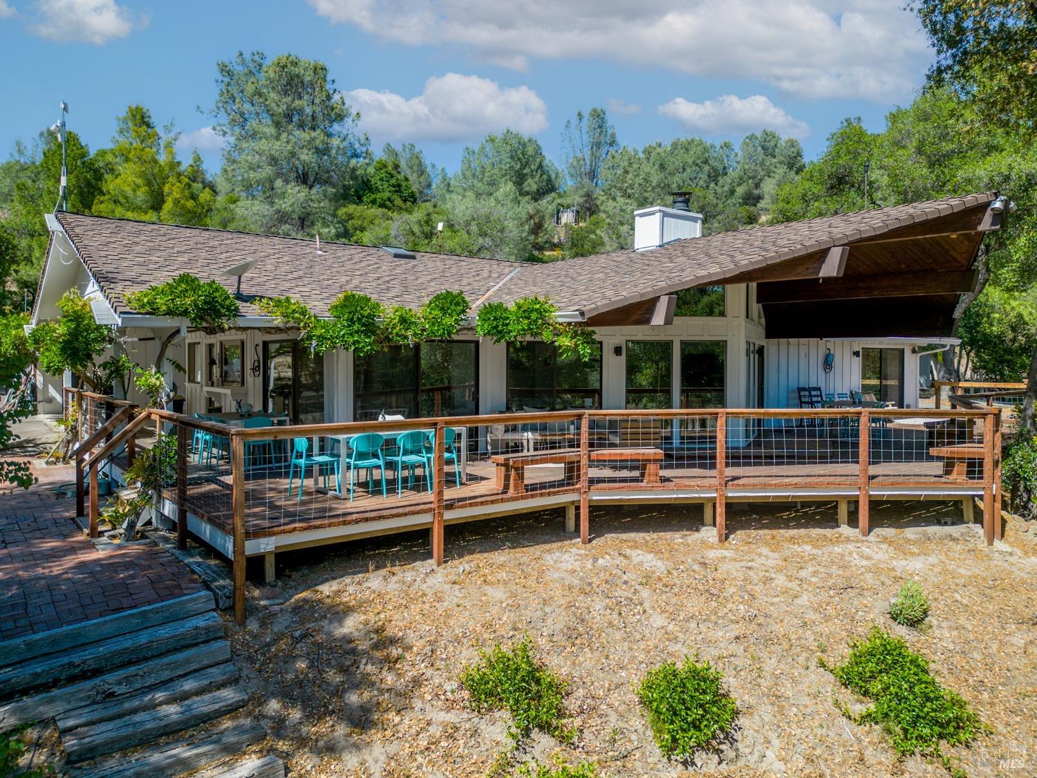 a view of a roof deck with wooden fence and a bench