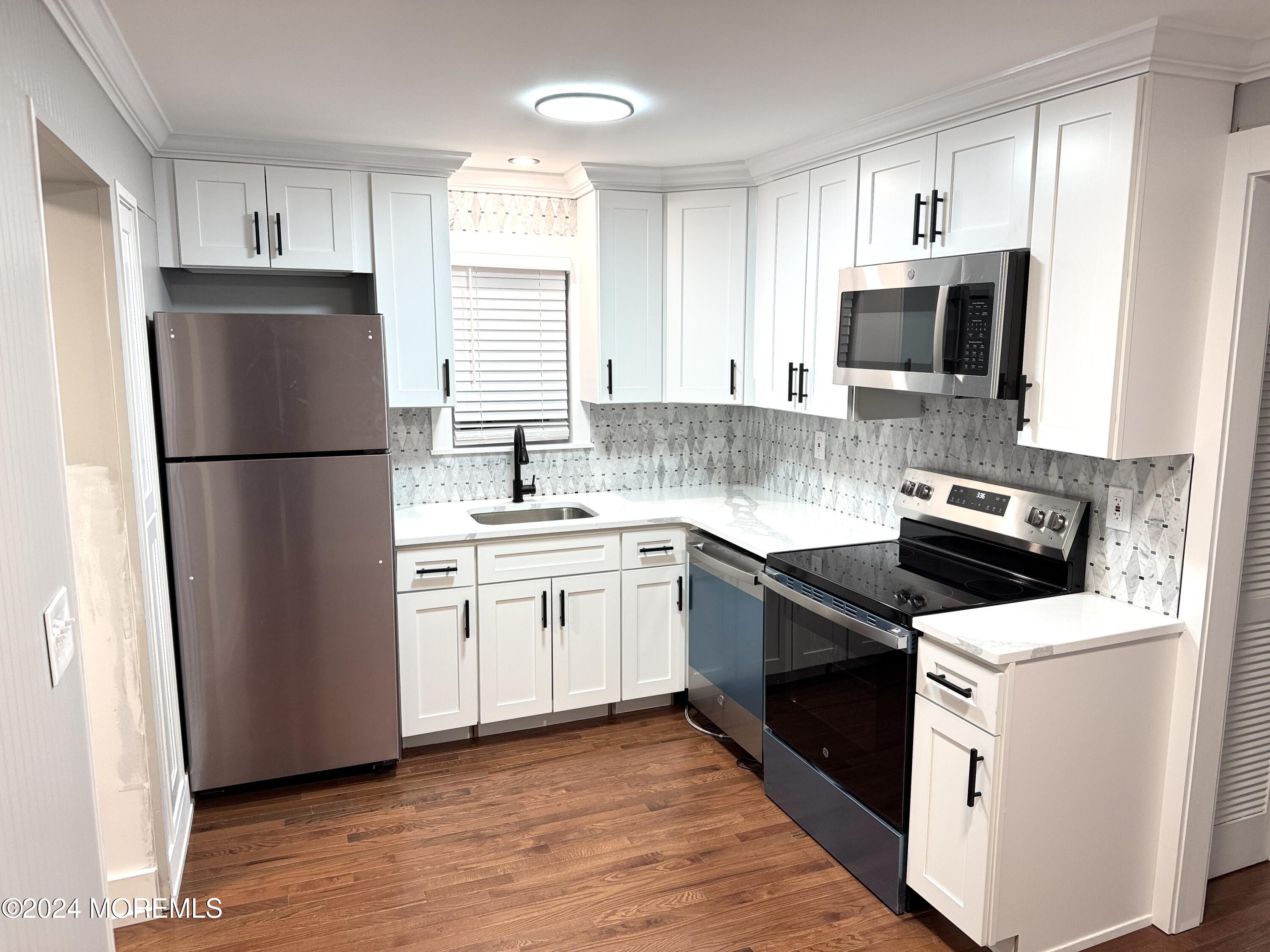 a kitchen with a refrigerator stove and sink