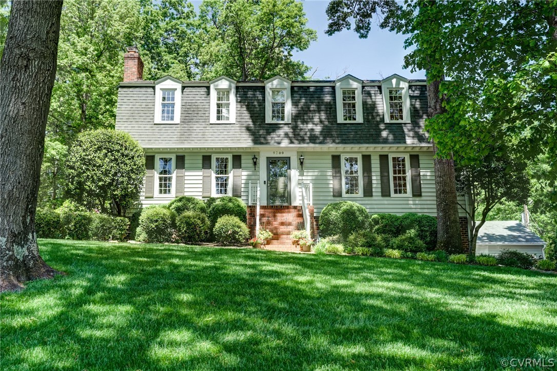 a front view of a house with a yard and potted plants