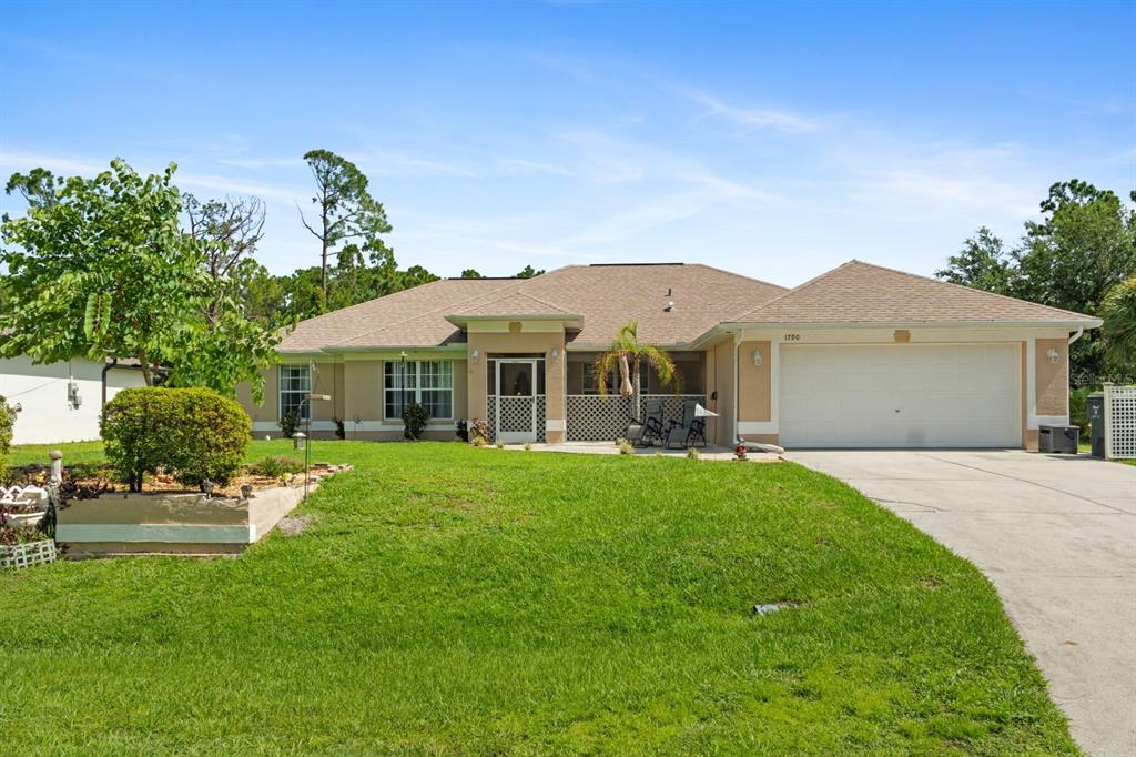 a front view of a house with a garden and yard