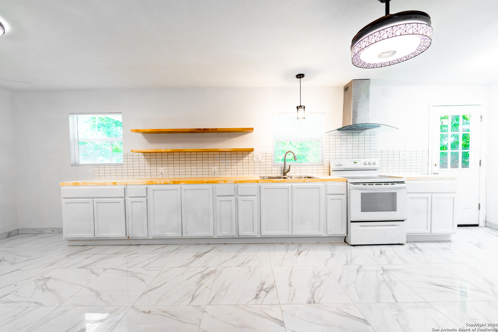 a kitchen with white cabinets and window