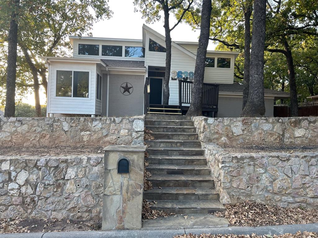 a front view of a house with a tree