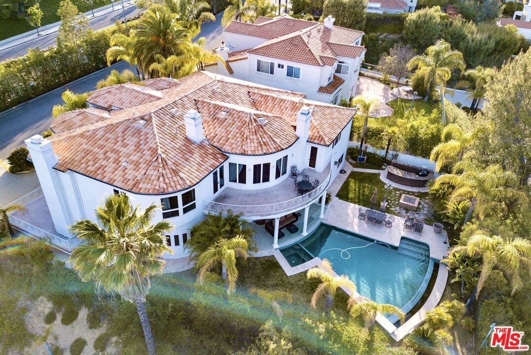 an aerial view of a house with swimming pool and outdoor seating