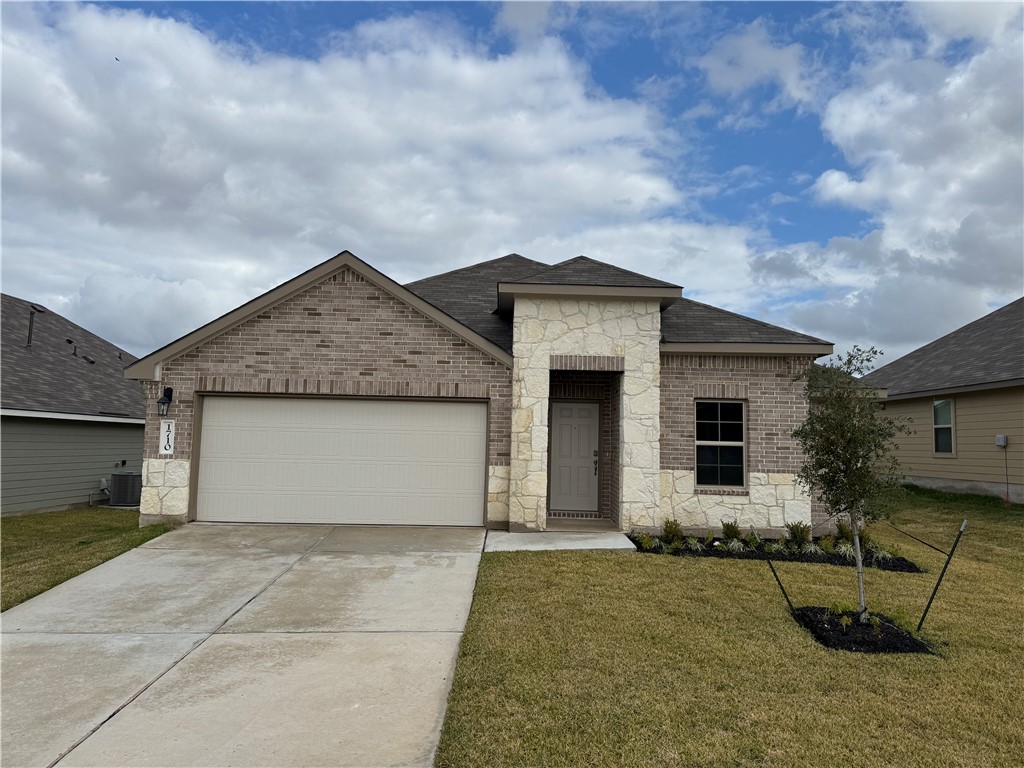 View of front of home with central AC, a garage, a