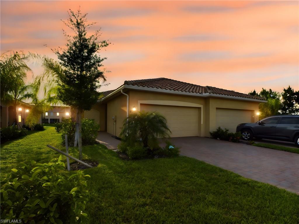 View of front of house featuring a garage and a yard