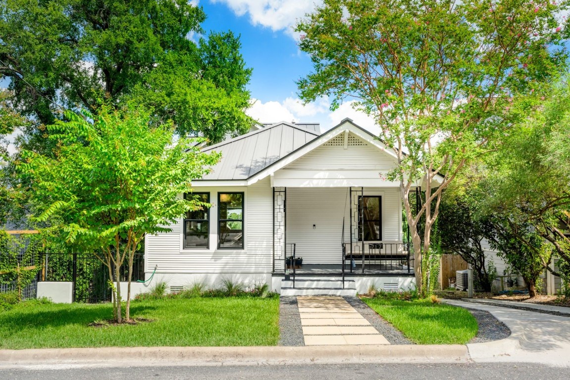 a front view of a house with a garden and trees