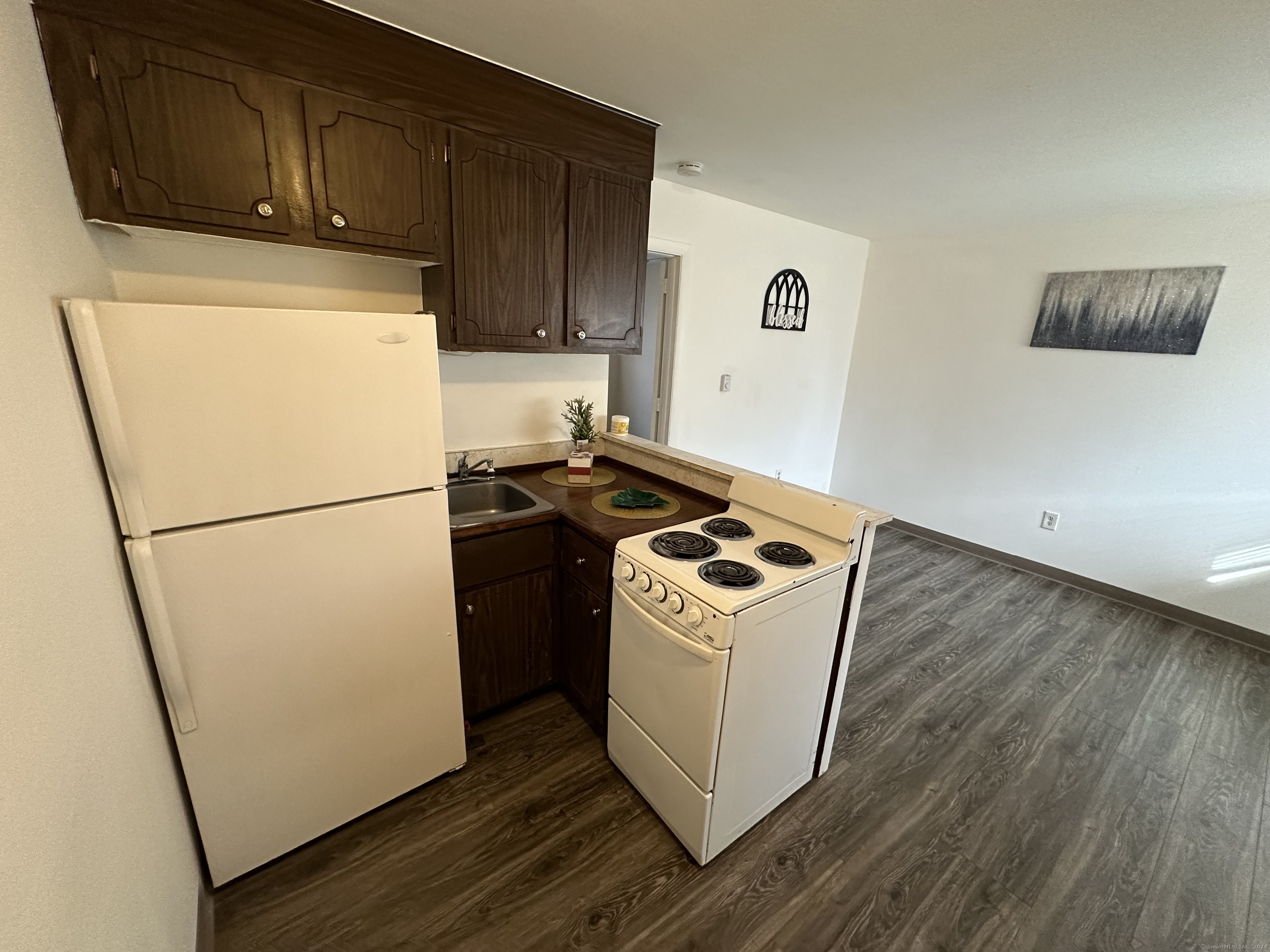 a utility room with wooden floor washer and dryer