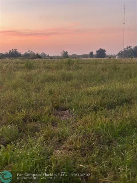 a view of a field with a lake in the background