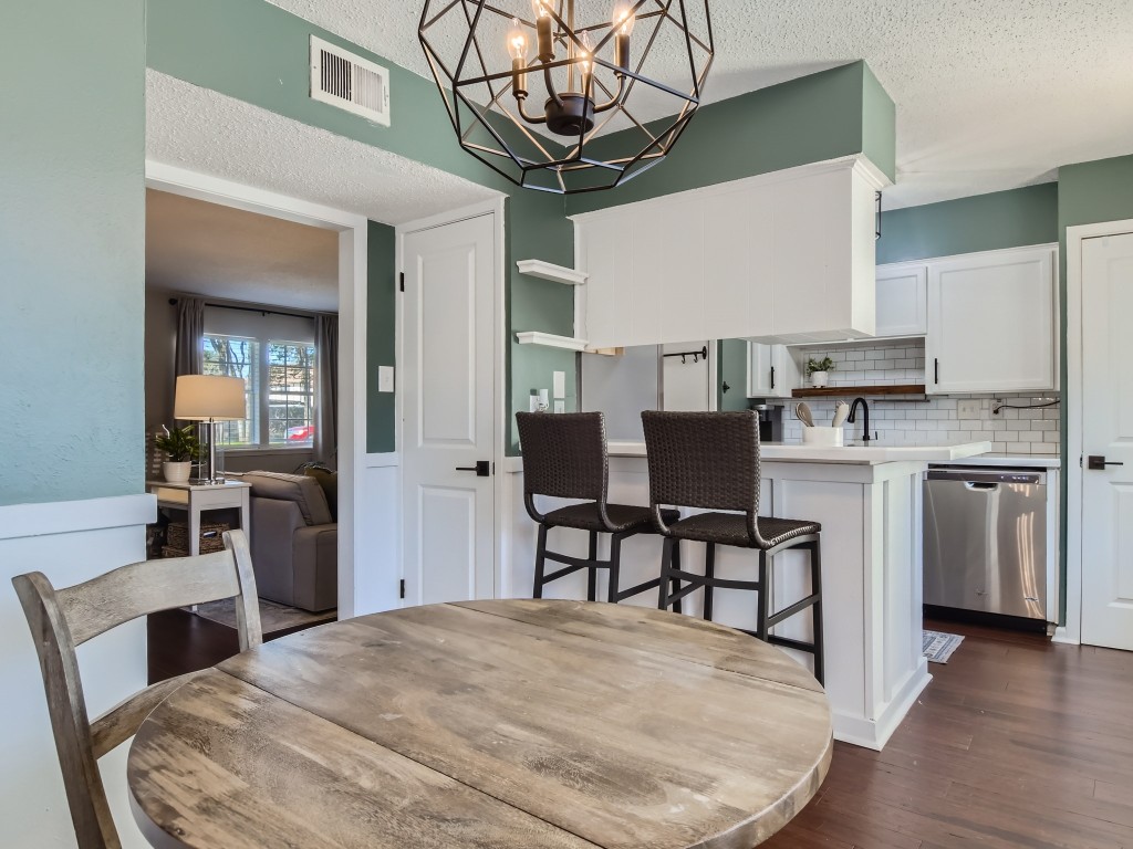 a kitchen with stainless steel appliances a table and chairs in it