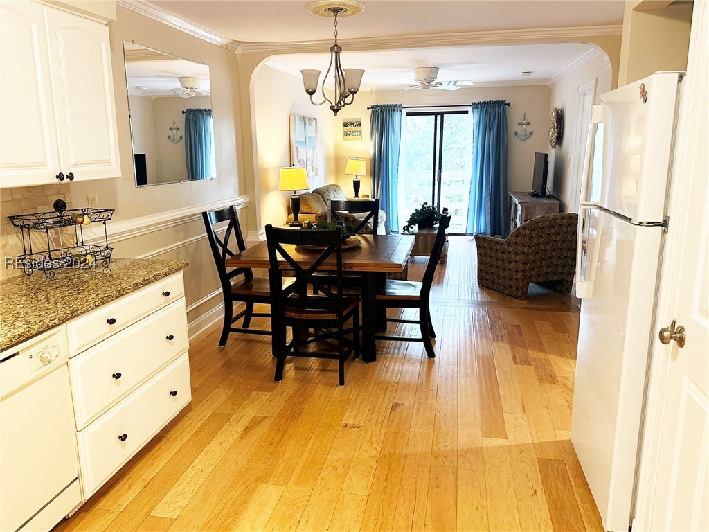 Dining space featuring crown molding, light hardwo