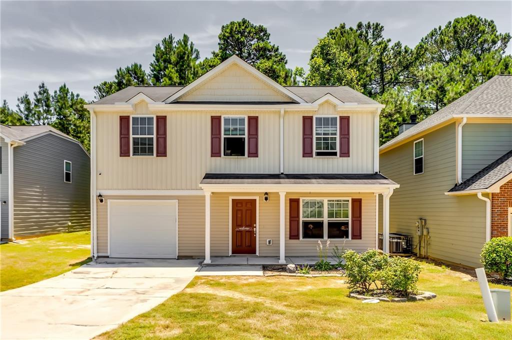 a front view of a house with a yard outdoor seating and garage