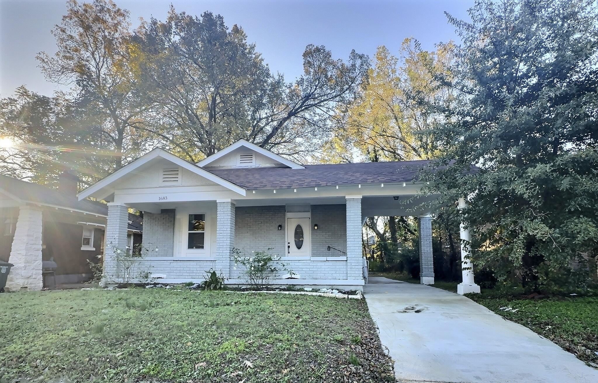 View of front facade featuring a front lawn and a carport