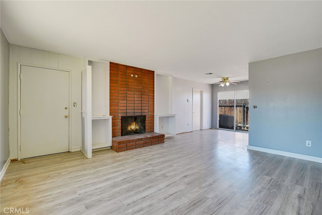 a view of empty room with a fireplace and wooden floor