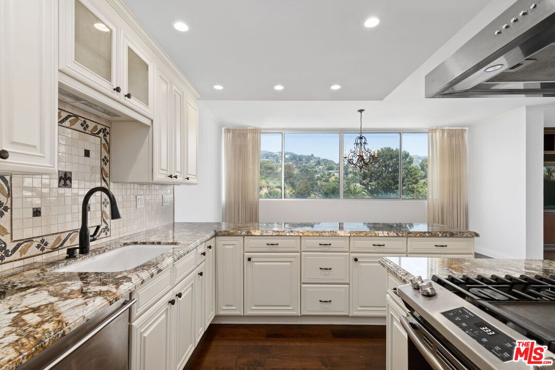 a kitchen with a sink stove top oven and cabinets