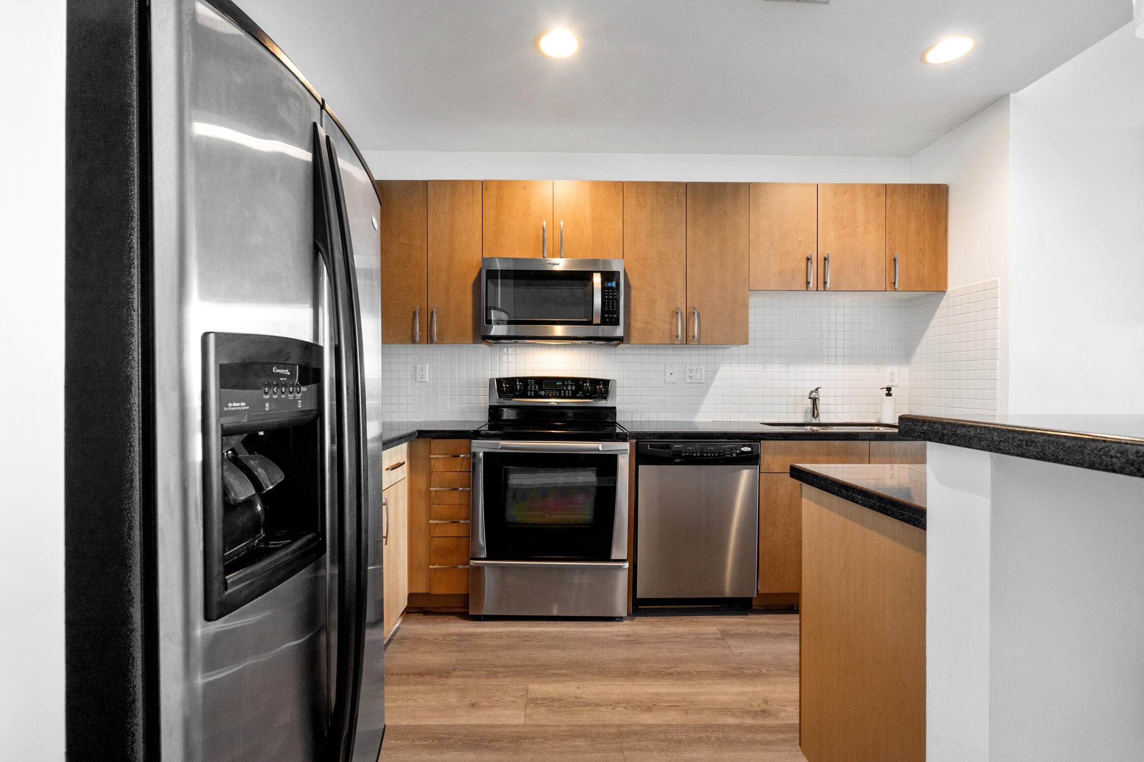 a kitchen with stainless steel appliances granite countertop a refrigerator and a stove