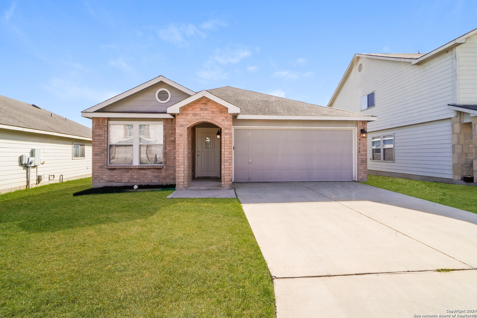 a front view of a house with a yard and garage