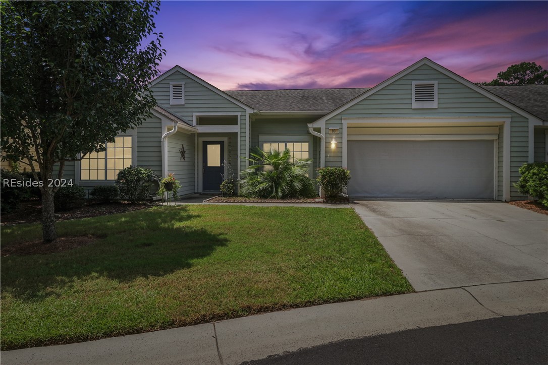 Single story home with a garage and a yard