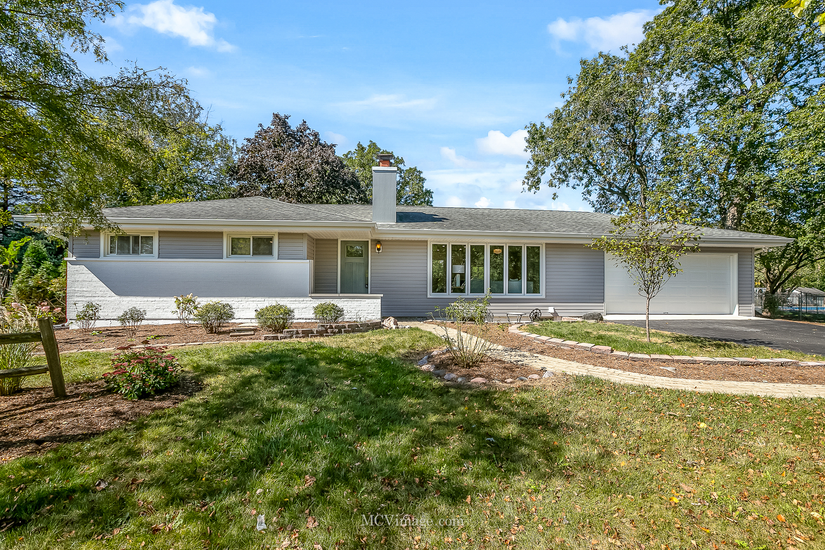 a view of a house with a backyard and a tree