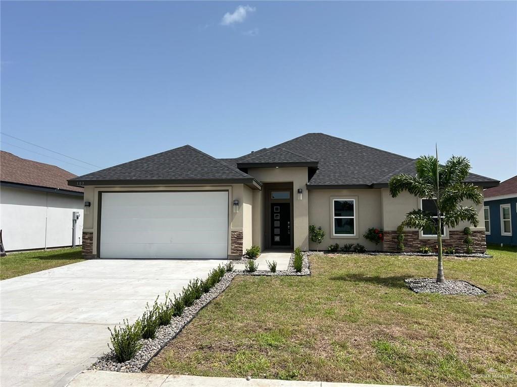 Prairie-style house featuring a garage and a front lawn