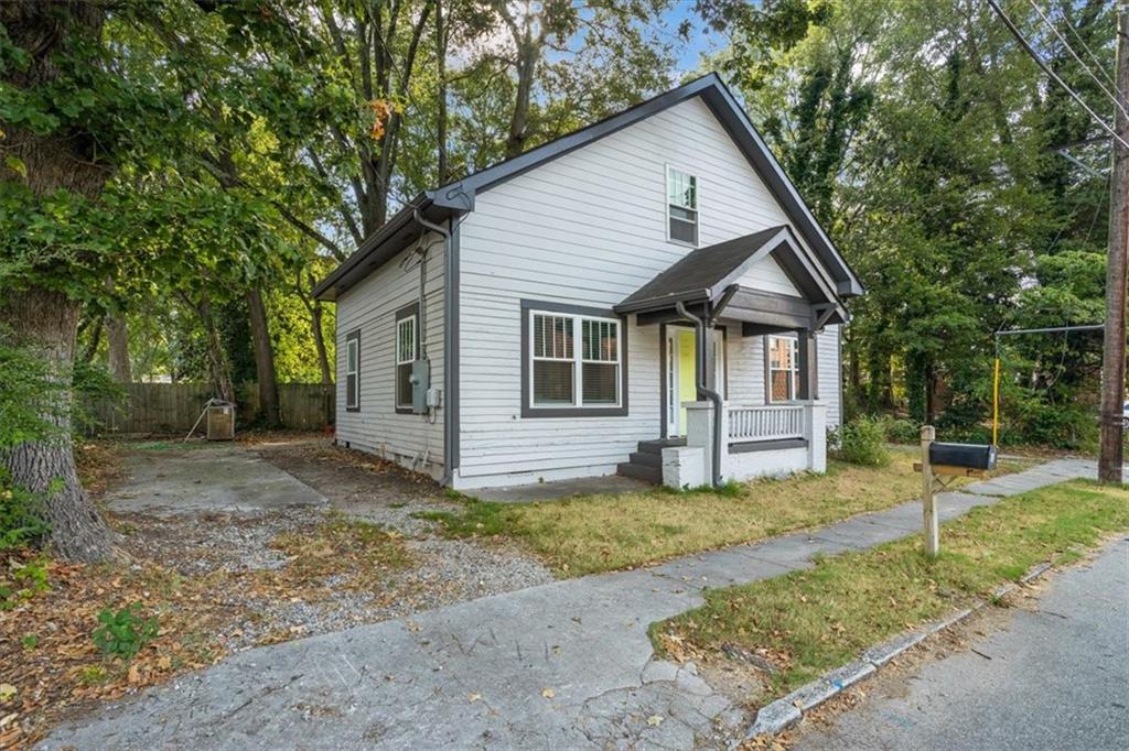 a view of a house with a yard and large tree