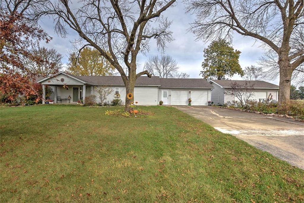 a front view of a house with a garden and trees