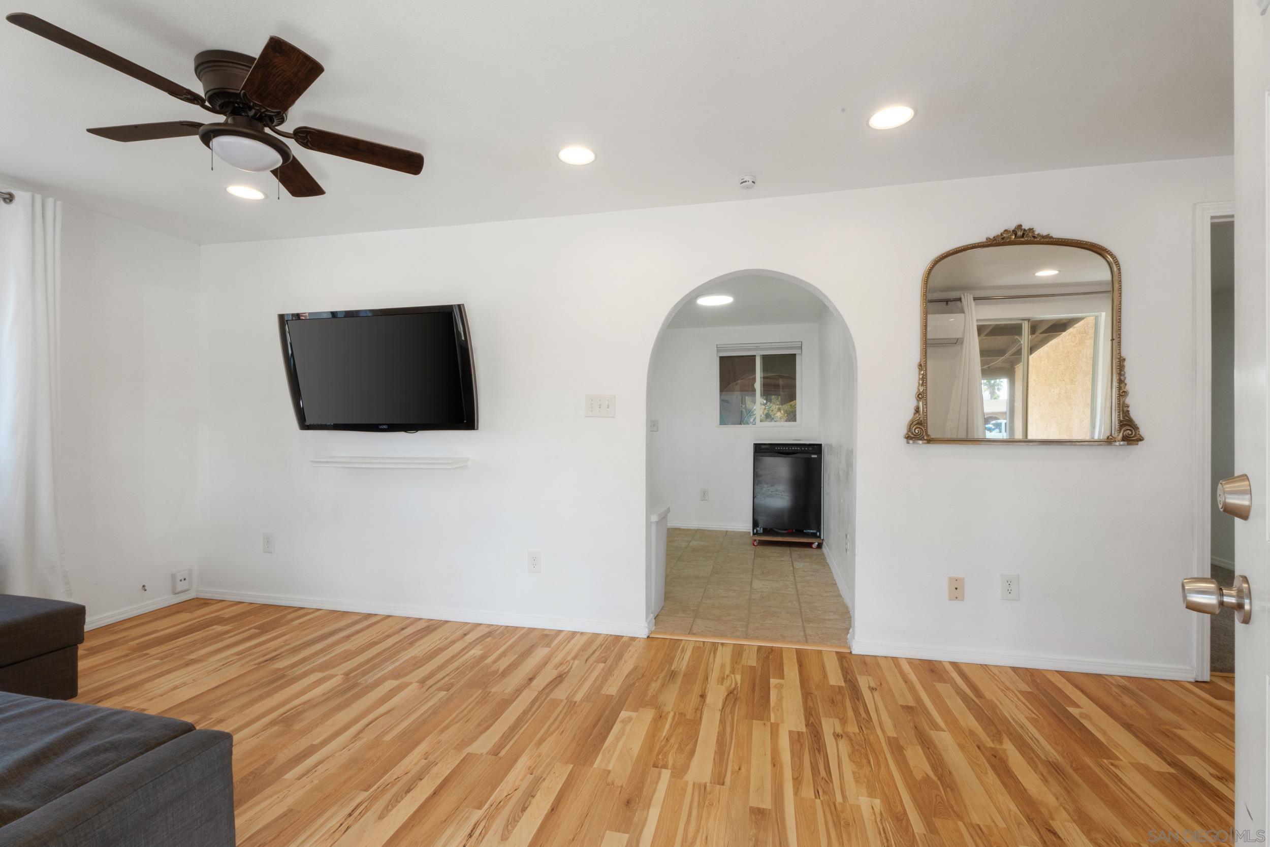 a view of empty room with wooden floor and window