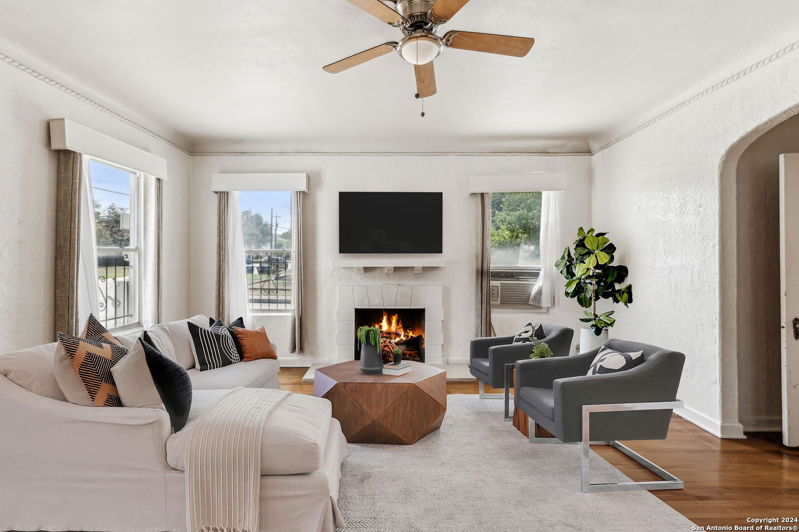 a living room with furniture a fireplace and a flat screen tv