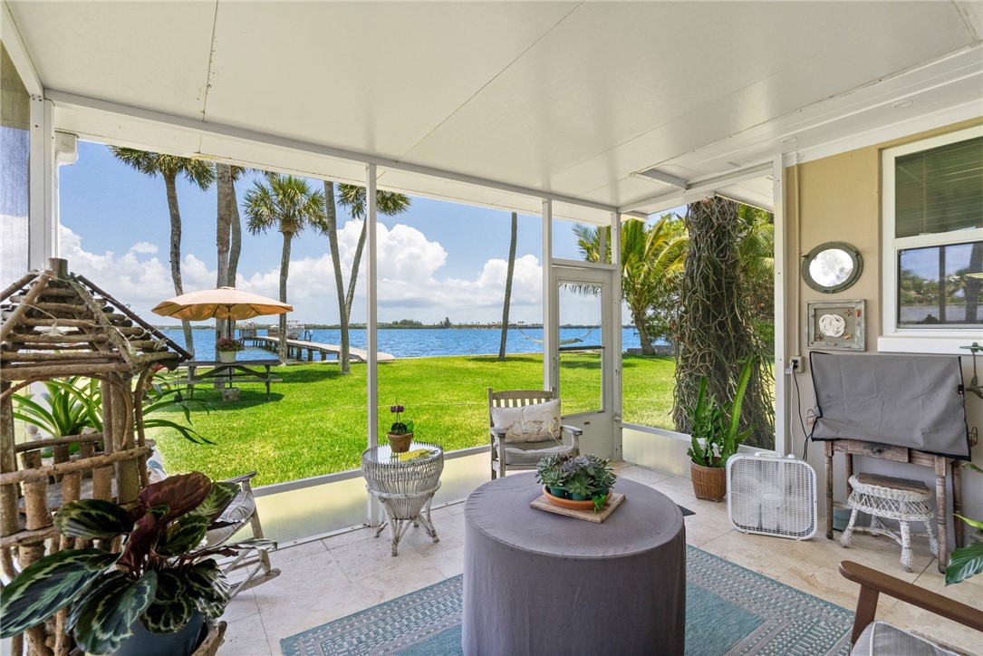 a living room with patio furniture and a garden