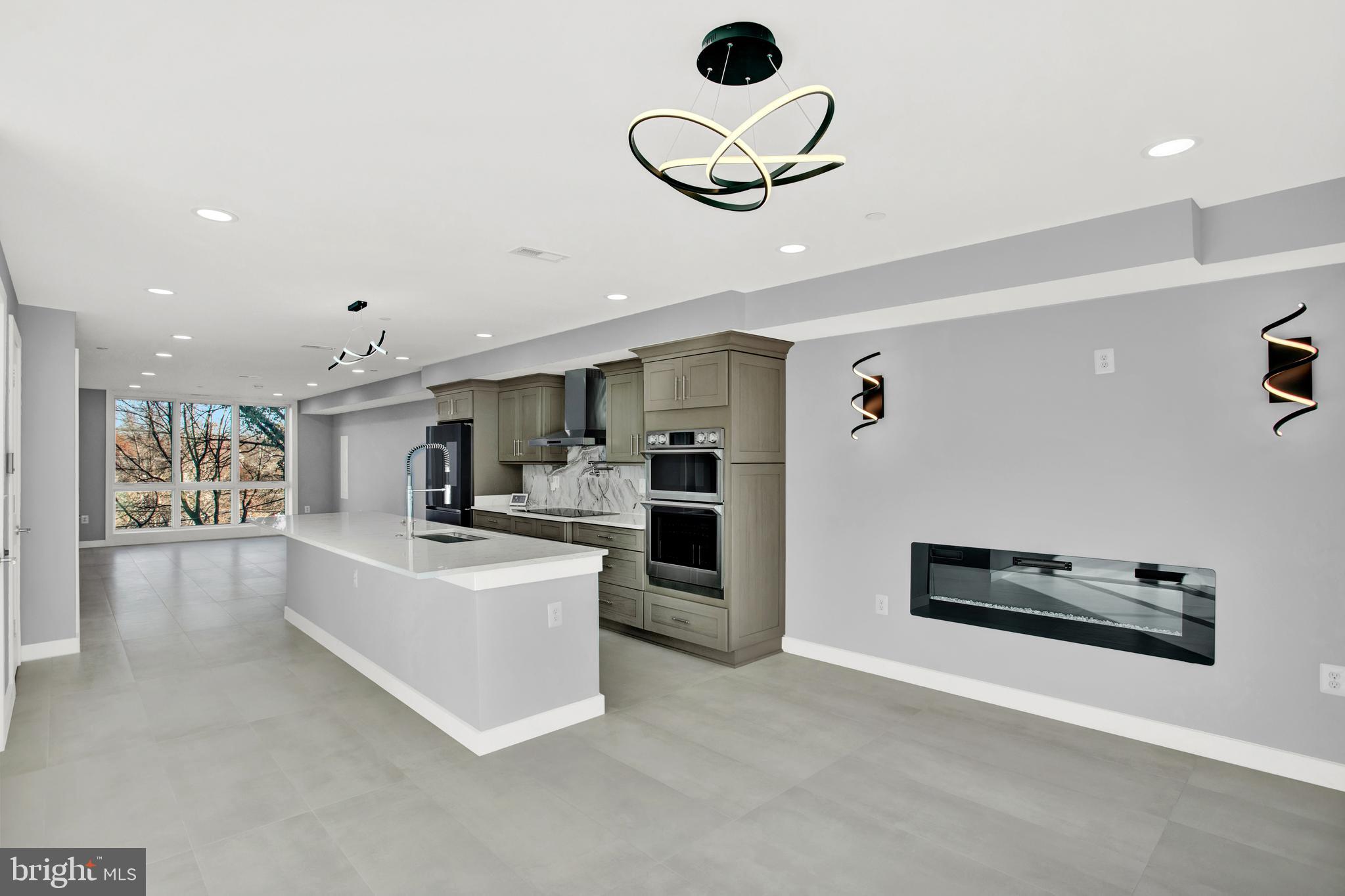 a living room with stainless steel appliances kitchen island furniture and kitchen view