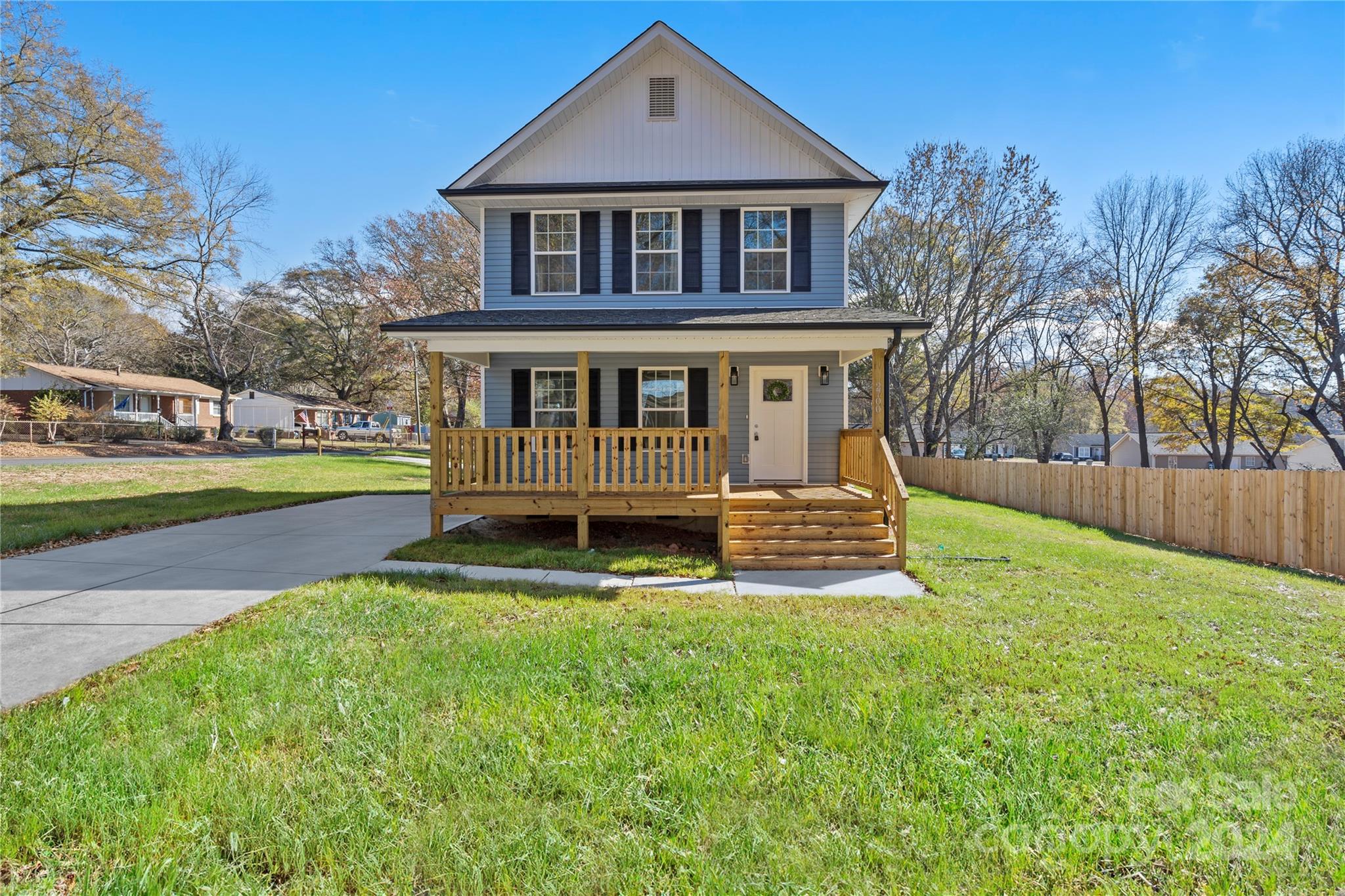 a view of a house with a yard deck and a small yard