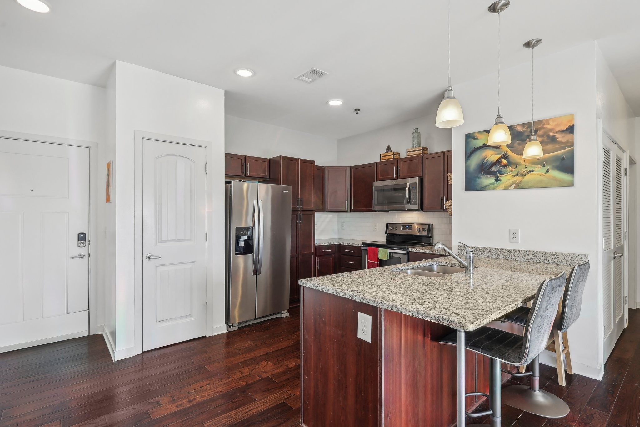 a kitchen with stainless steel appliances granite countertop a refrigerator and a stove top oven