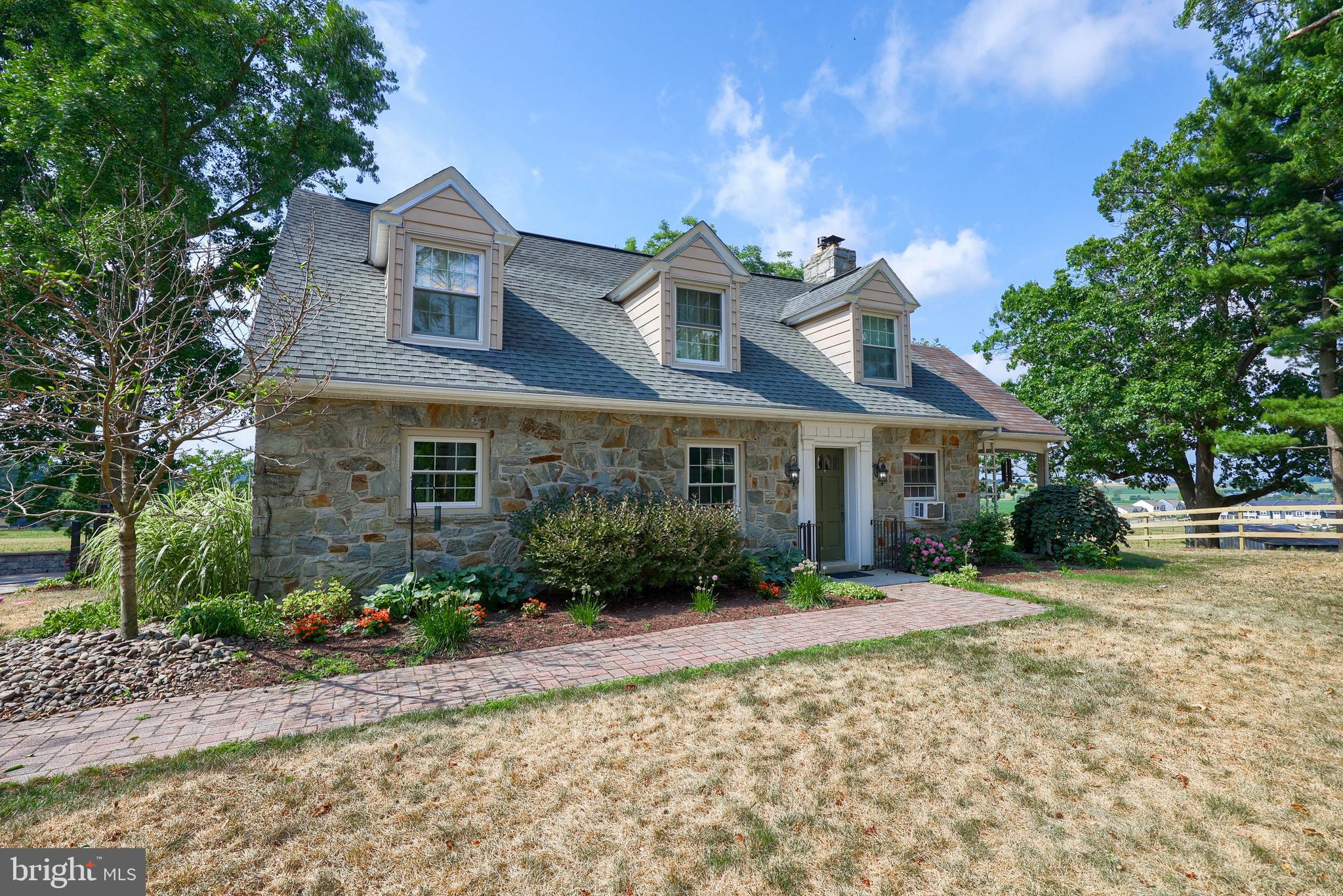 a front view of a house with a yard and potted plants